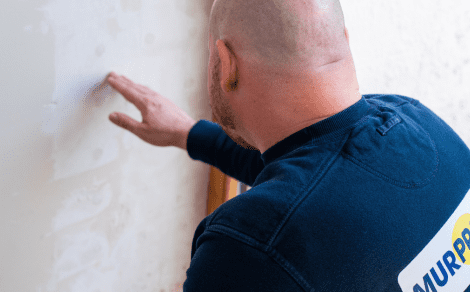 Murprotec-Feuchtigkeitsexperte untersucht eine feuchte Wand. 